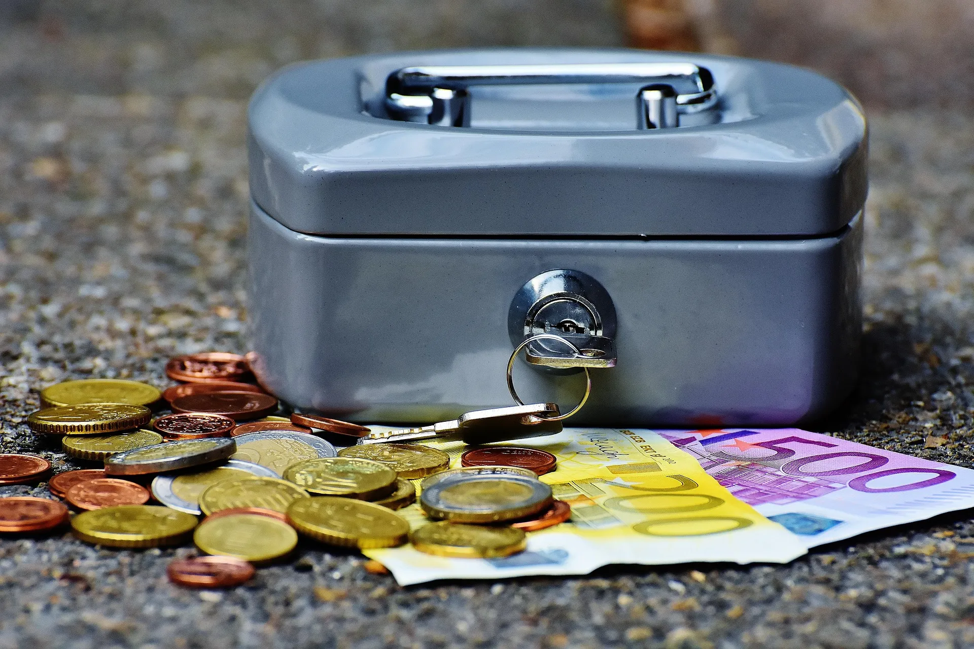 Geld, munten en een kasbox als symbool voor financiële controle en een gezonde cashflow.