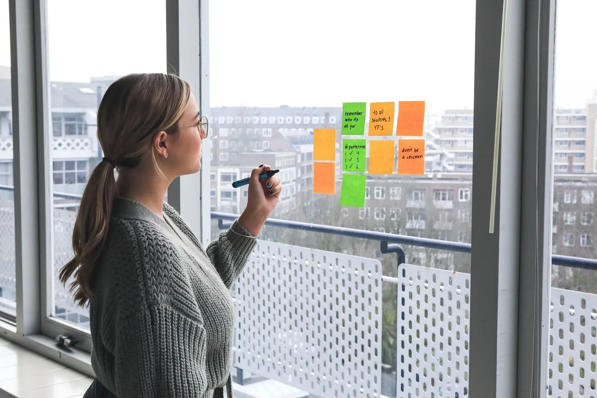 Een ondernemer ordent taken met notities om focus te houden en de belangrijkste doelen eerst aan te pakken.