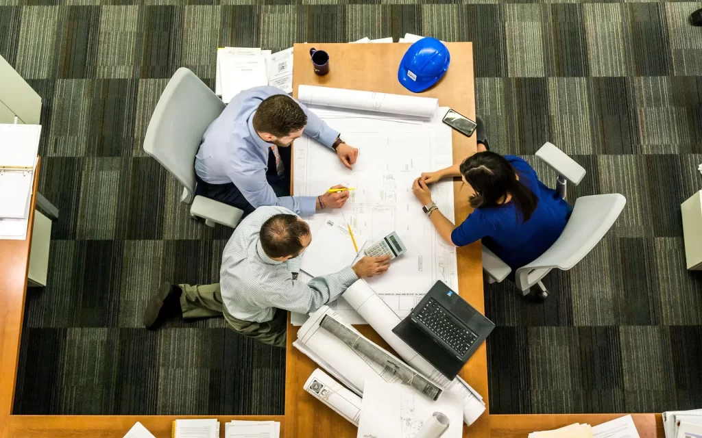 Een team werkt samen aan plannen en documenten als basis voor structuur, groei en duidelijke bedrijfsdoelen.