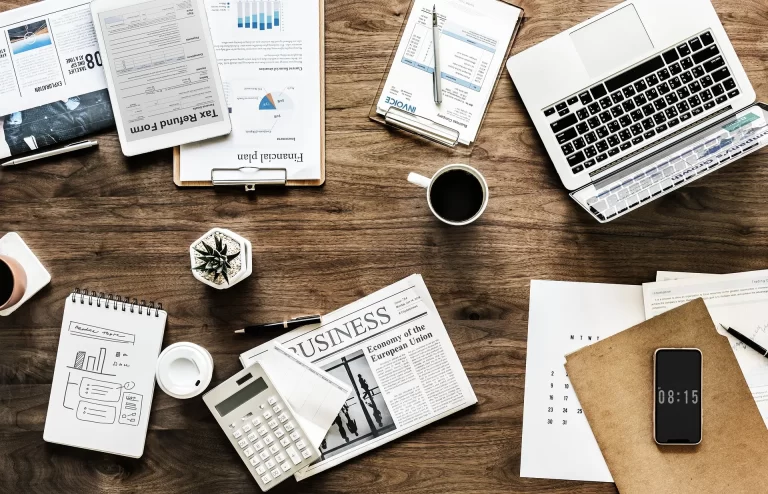 Een georganiseerde werktafel met laptop, agenda en documenten als basis voor consistente social media planning.