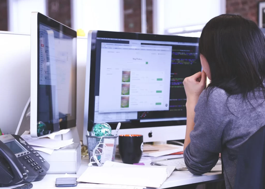 Een georganiseerde werkplek met meerdere schermen als symbool voor efficiënt e-mailbeheer en betere planning.